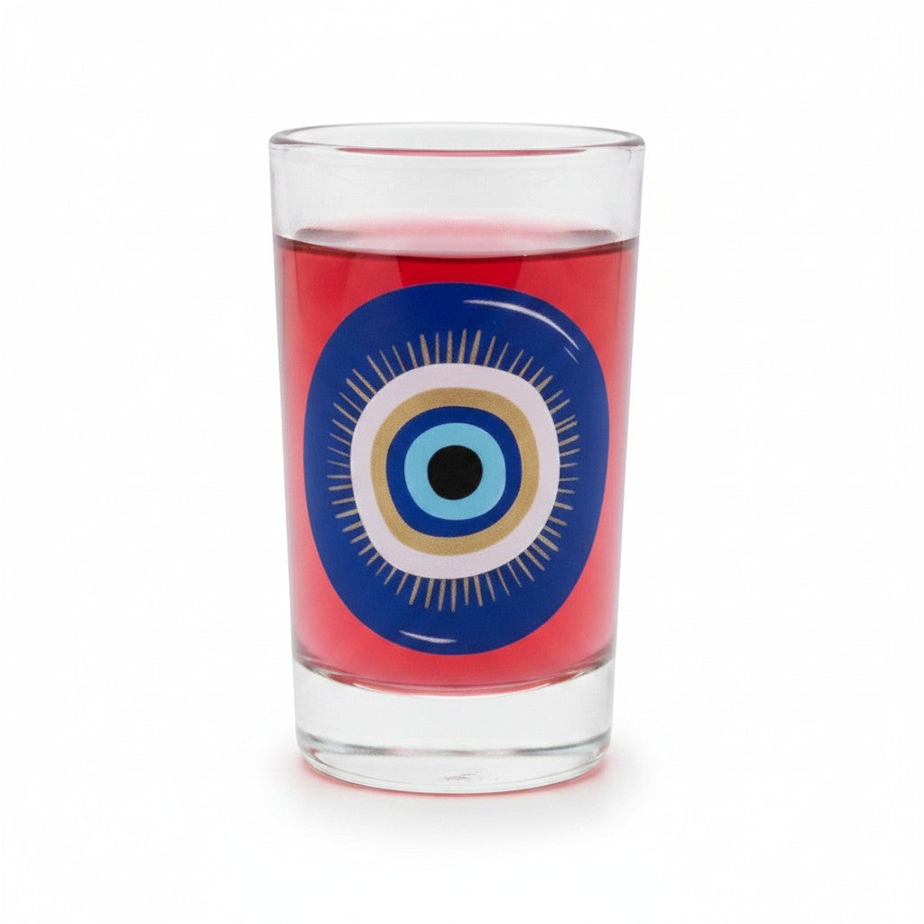 Mati Made small clear glass with a vibrant blue and gold mati evil eye motif filled with a red beverage