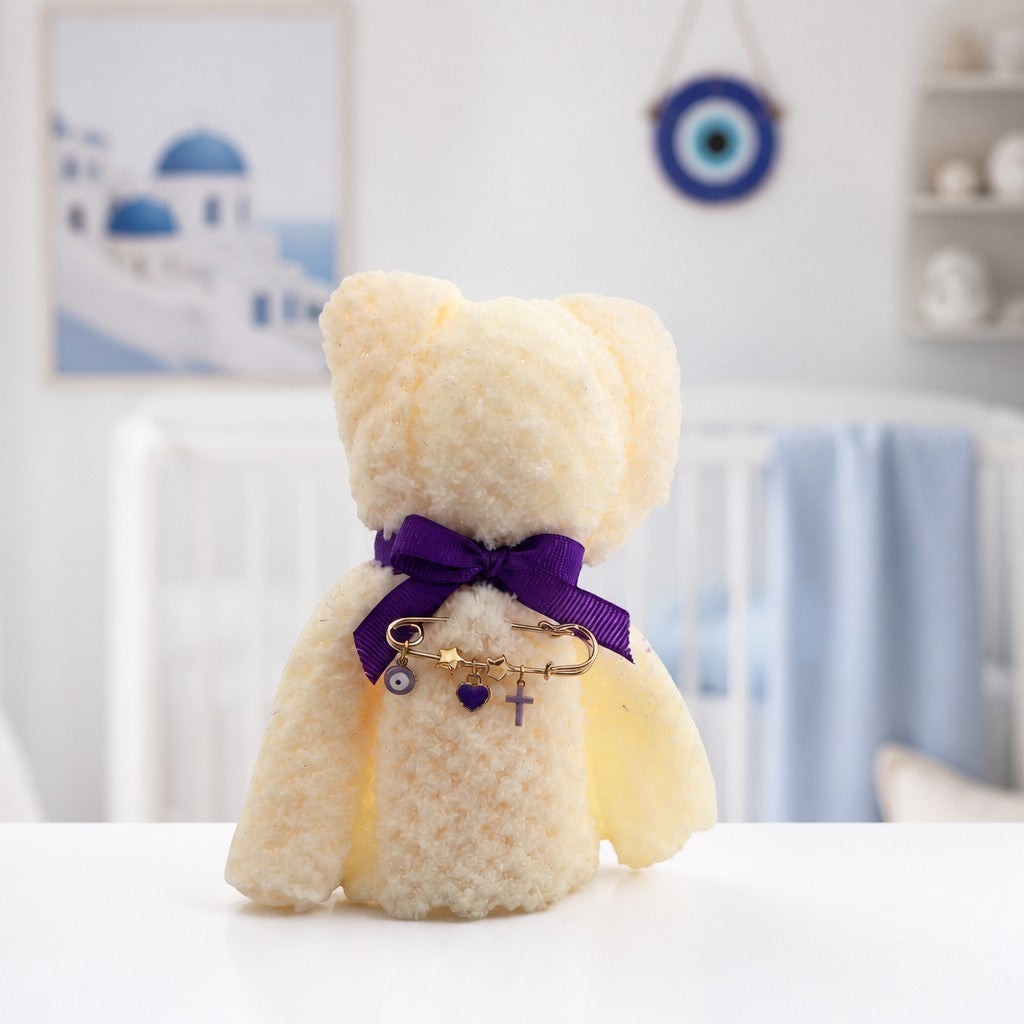 Mati Made cream plush teddy bear ornament with a purple ribbon and gold charm pin featuring an evil eye and heart