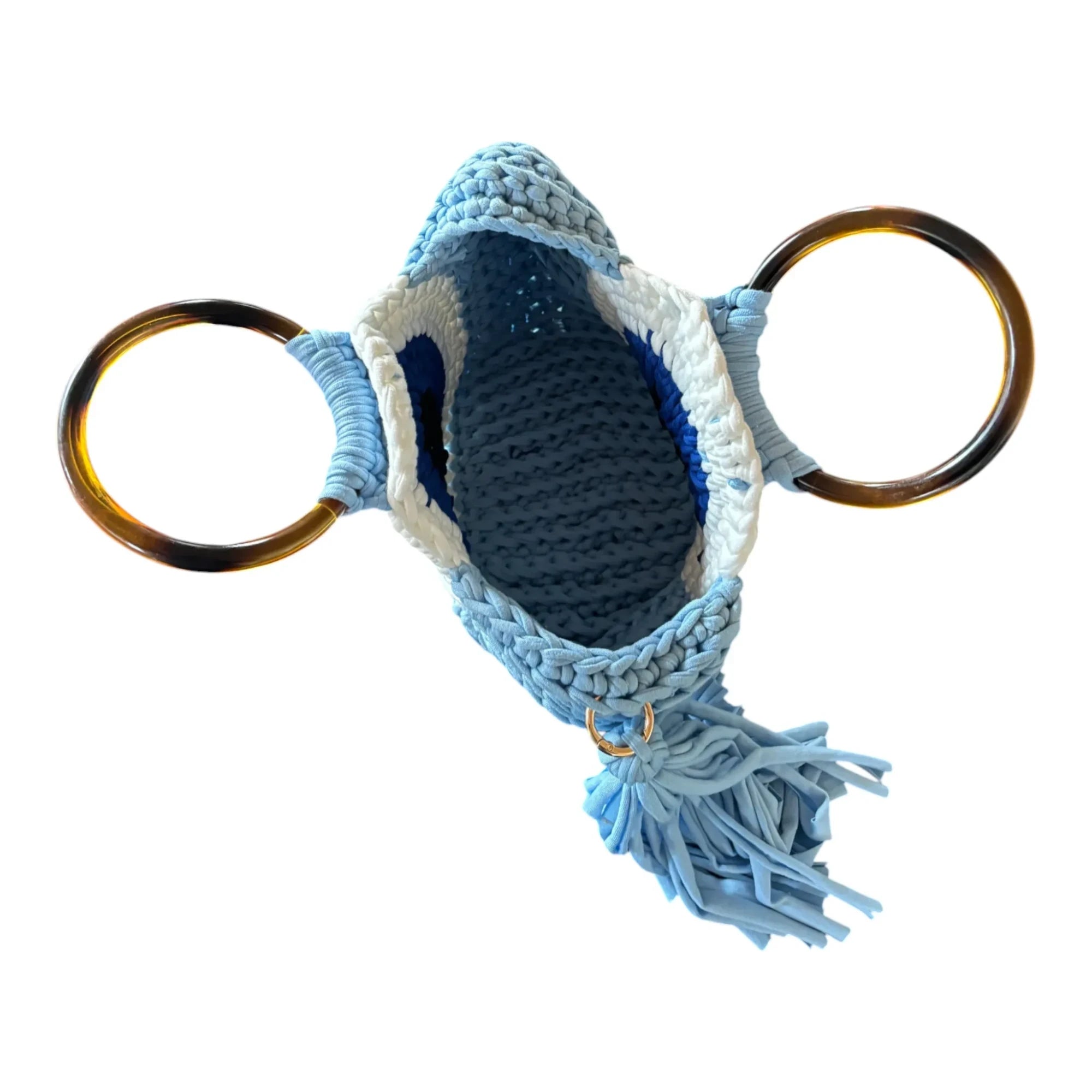 Mati Made handcrafted crochet hand bag in blue, white, and navy with tortoiseshell ring handles and a side tassel.