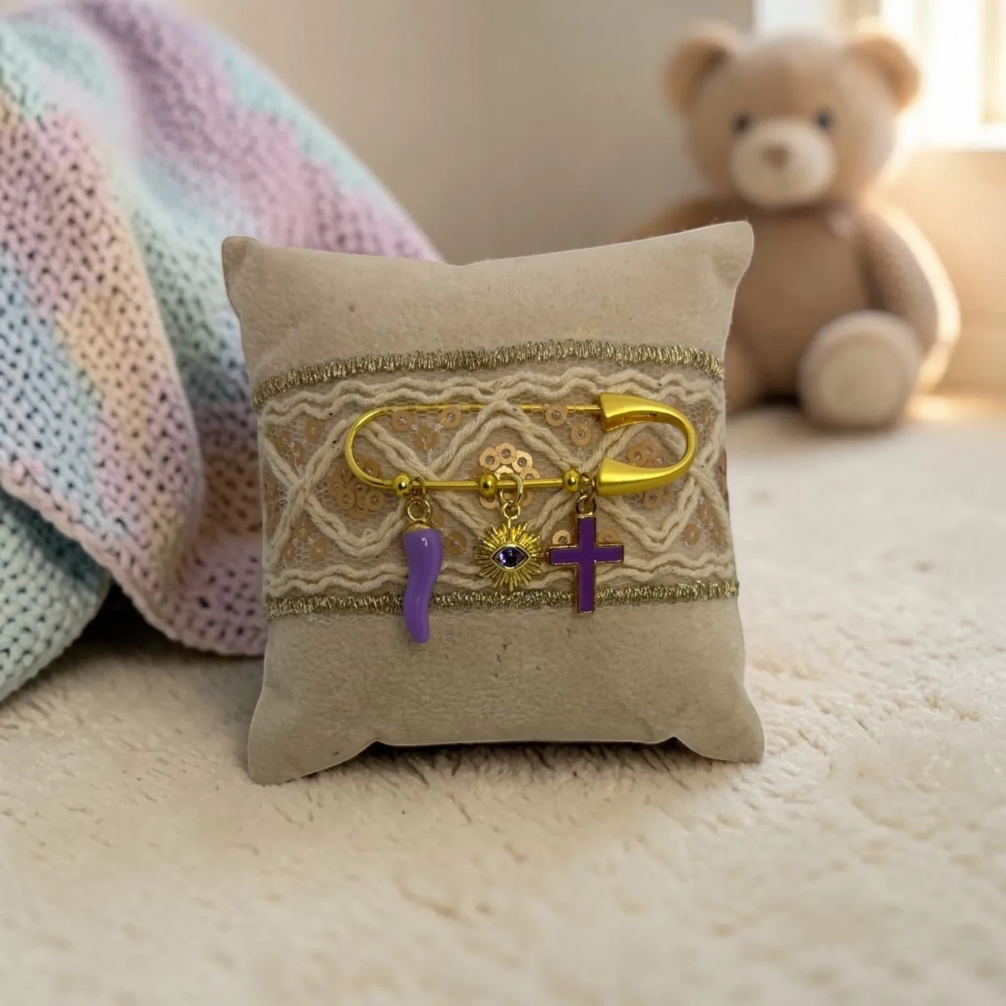Mati Made decorative keepsake pin cushion with lace, gold accents, and charms including an evil eye and purple cross.