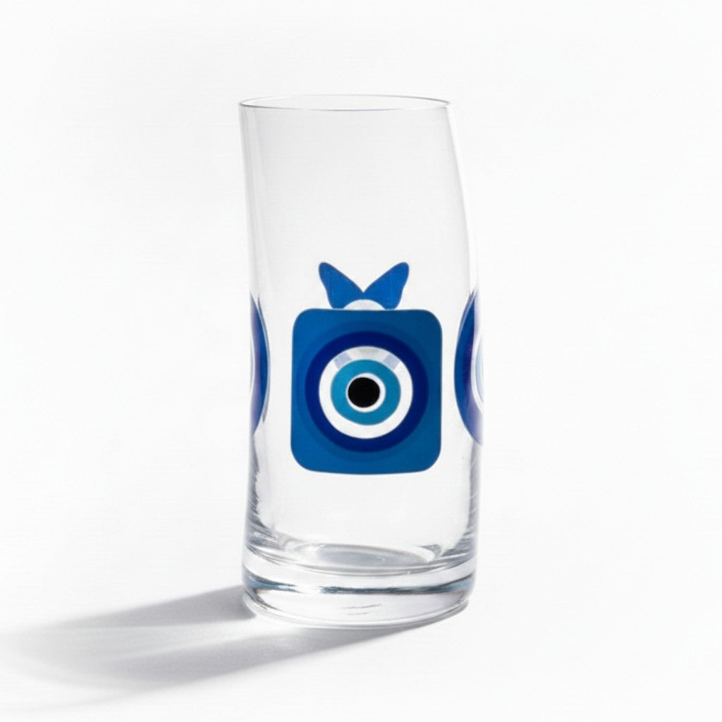Mati Made clear glass tumbler featuring a blue and black evil eye design with a unique curved silhouette.