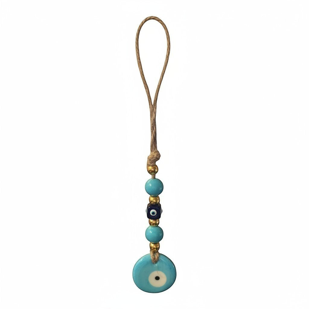 Mati Made handcrafted evil eye wall hanging with blue glass beads, gold accents, and rustic twine loop.