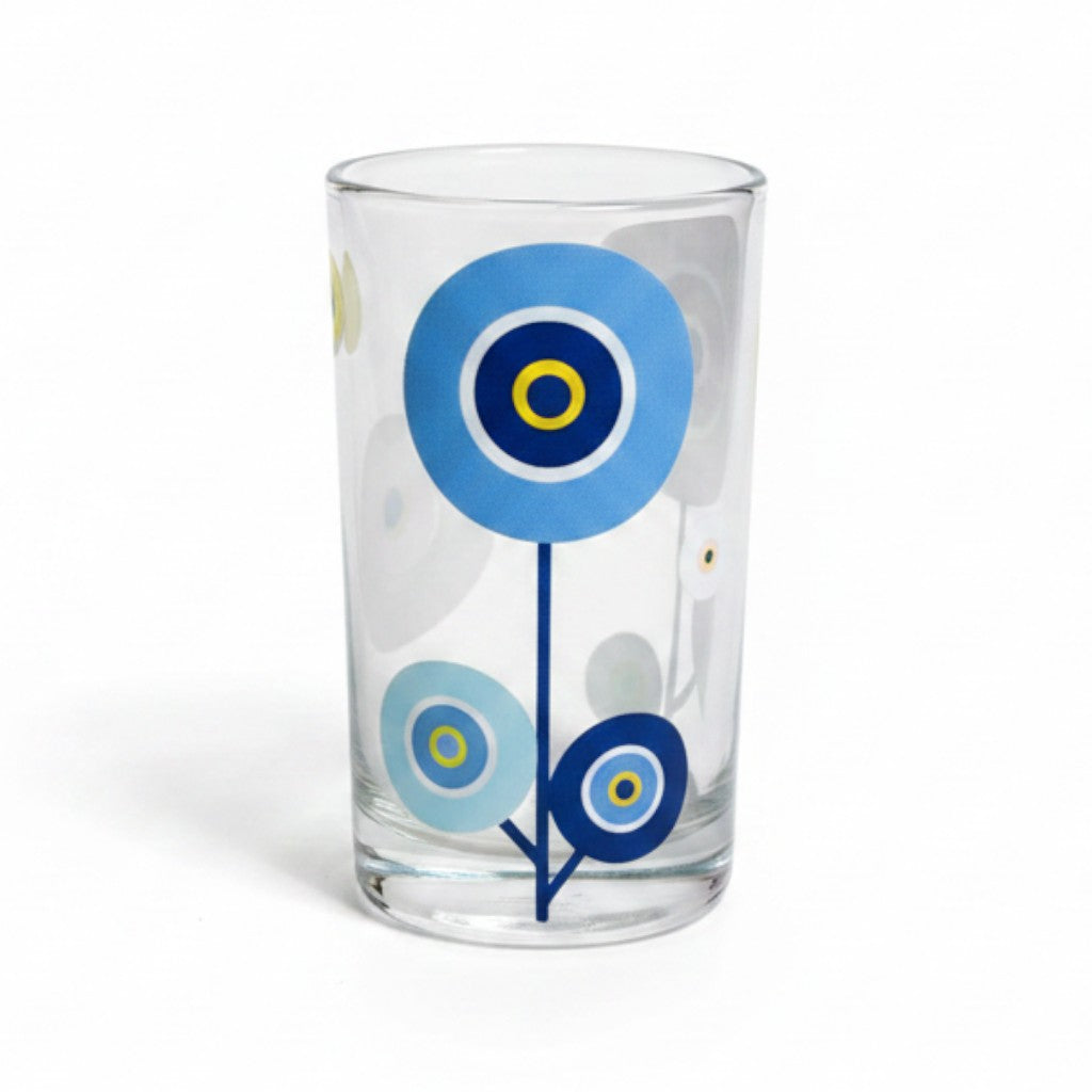 Mati Made clear glass tumbler featuring a whimsical blue circular floral motif on a sleek cylindrical silhouette.