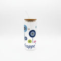 Mati Made clear glass tumbler with evil eye motif, bamboo lid, and glass straw, featuring blue, pink, and green art.