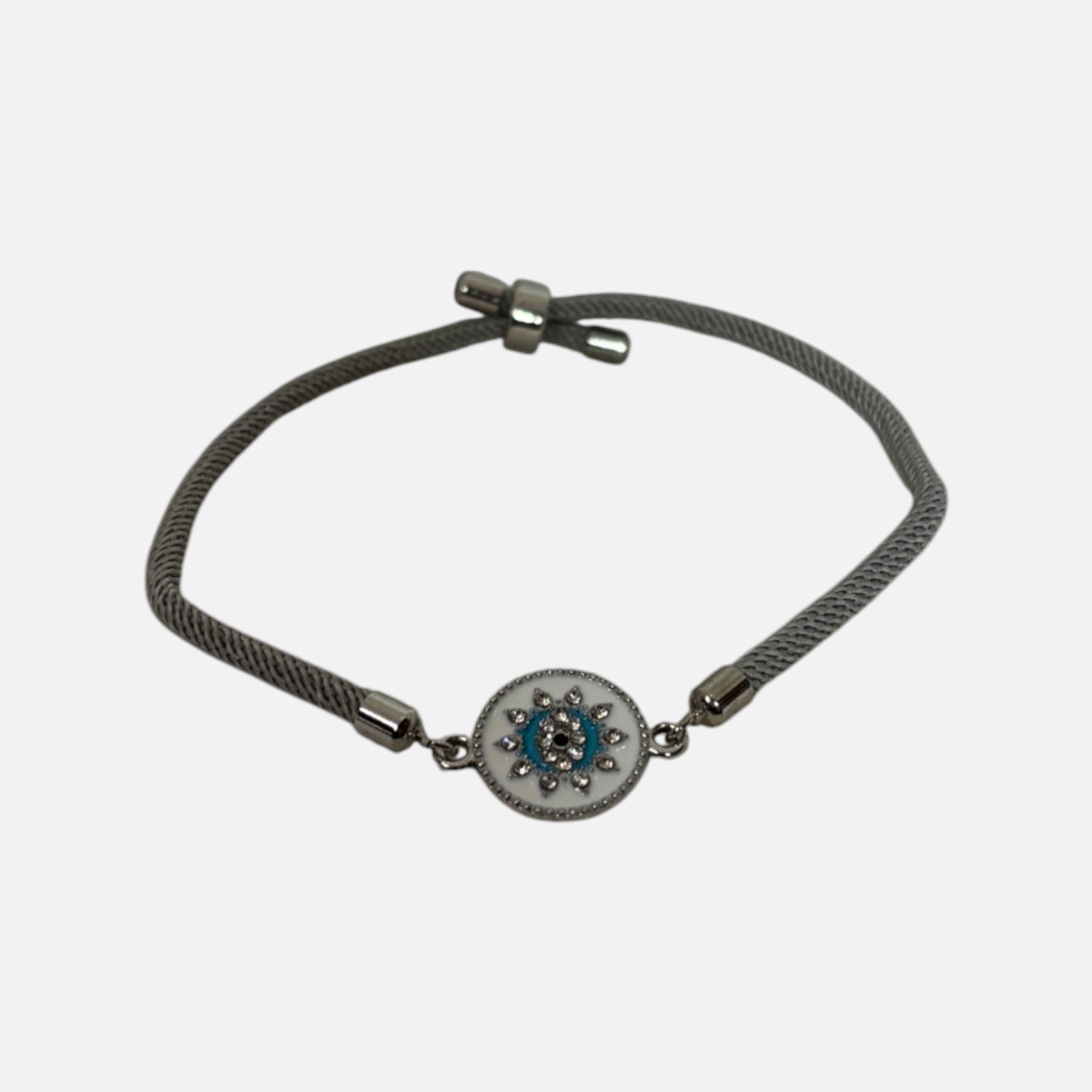 Mati Made grey cord bracelet featuring a circular evil eye charm with white enamel, blue accents, and crystals.