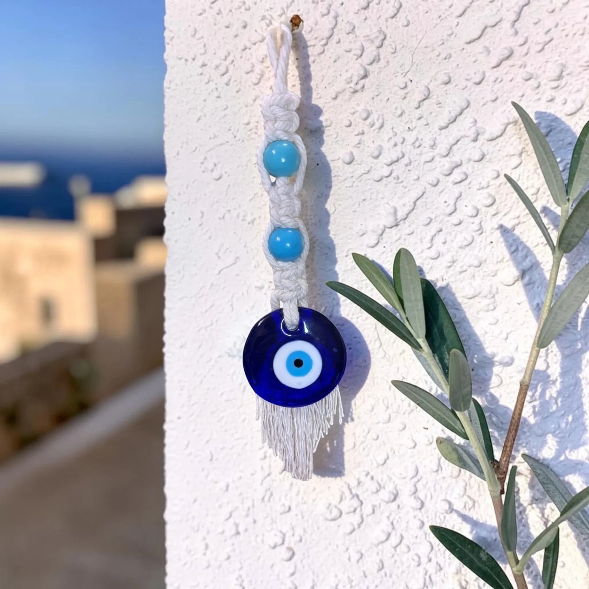 Mati Made handcrafted macrame evil eye wall hanging with white cotton cord and vibrant turquoise beads