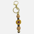 Mati Made mustard silicone bead key ring with gold hardware and evil eye charm accent for keys or bags.