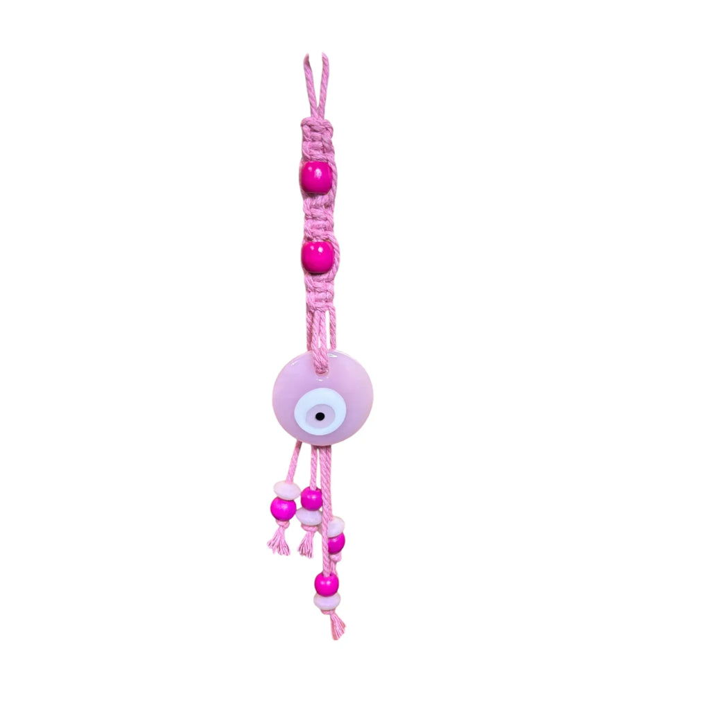 Mati Made pink macrame evil eye wall hanging with fuchsia wooden beads and a central glass charm for bohemian decor.